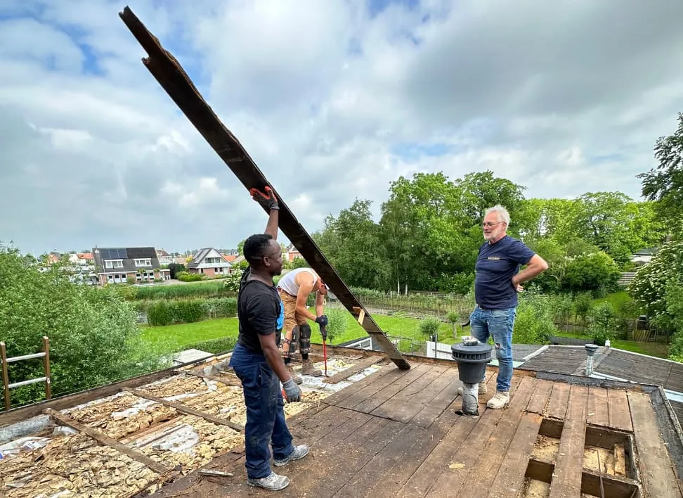 Bouwspot-team legt een nieuwe houten balk op een dakvlak