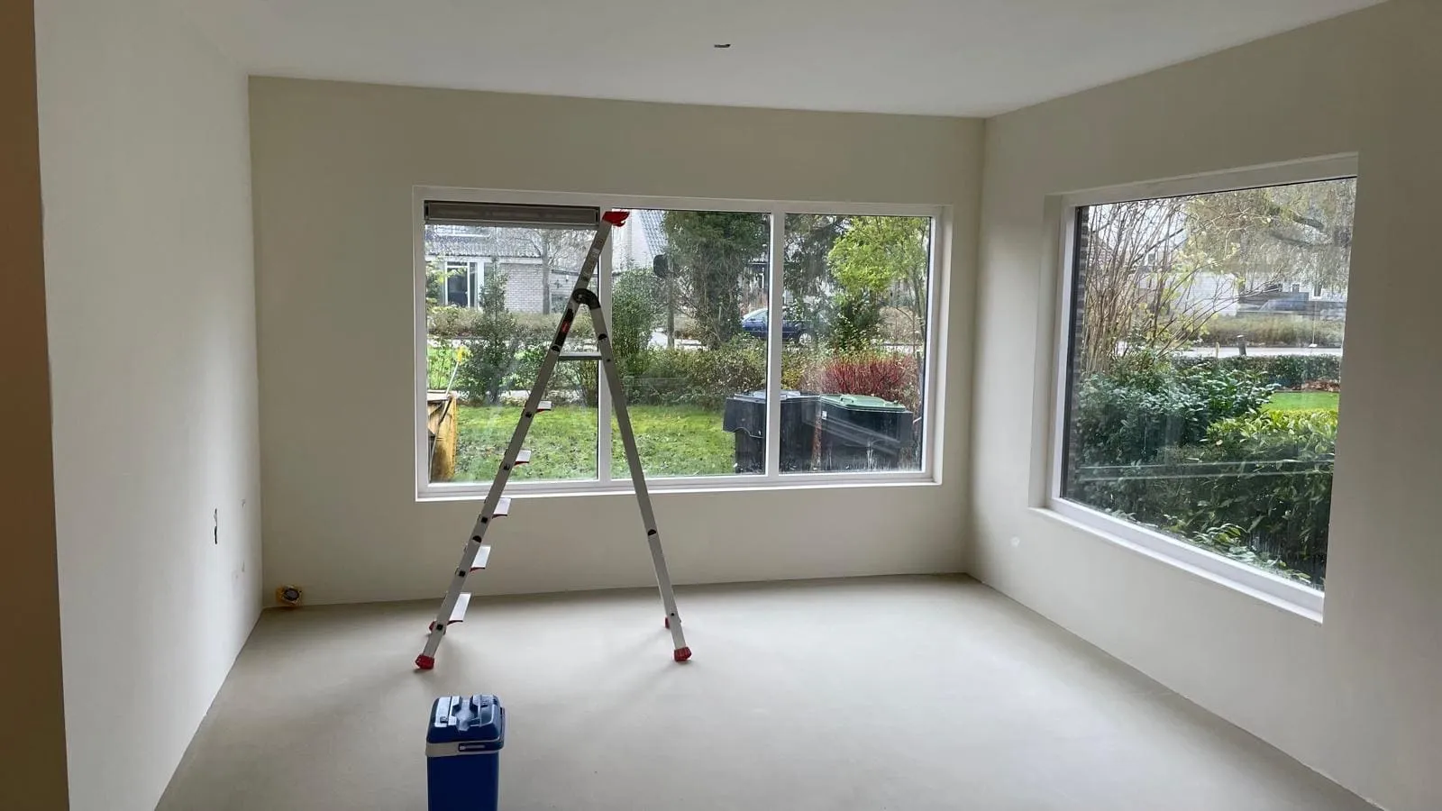 Gestucte lege woonkamer in Bedum met nieuwe hoekramen en een afgewerkte dekvloer